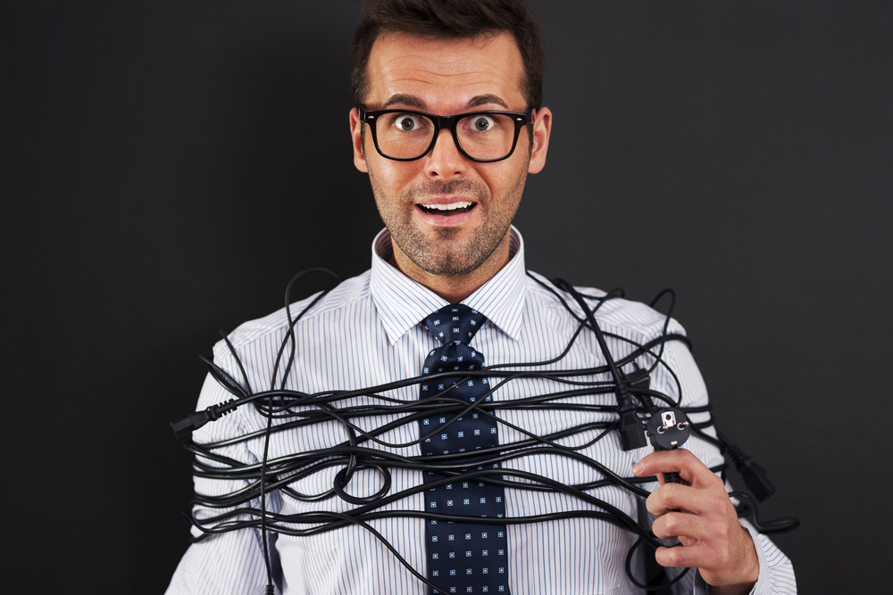 Young businessman with wires around his body