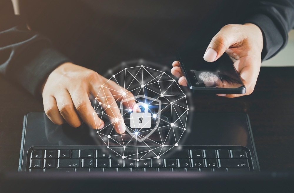 CyberSecurityConceptDoubleExposureOfEmployeeWorkingOnLaptop